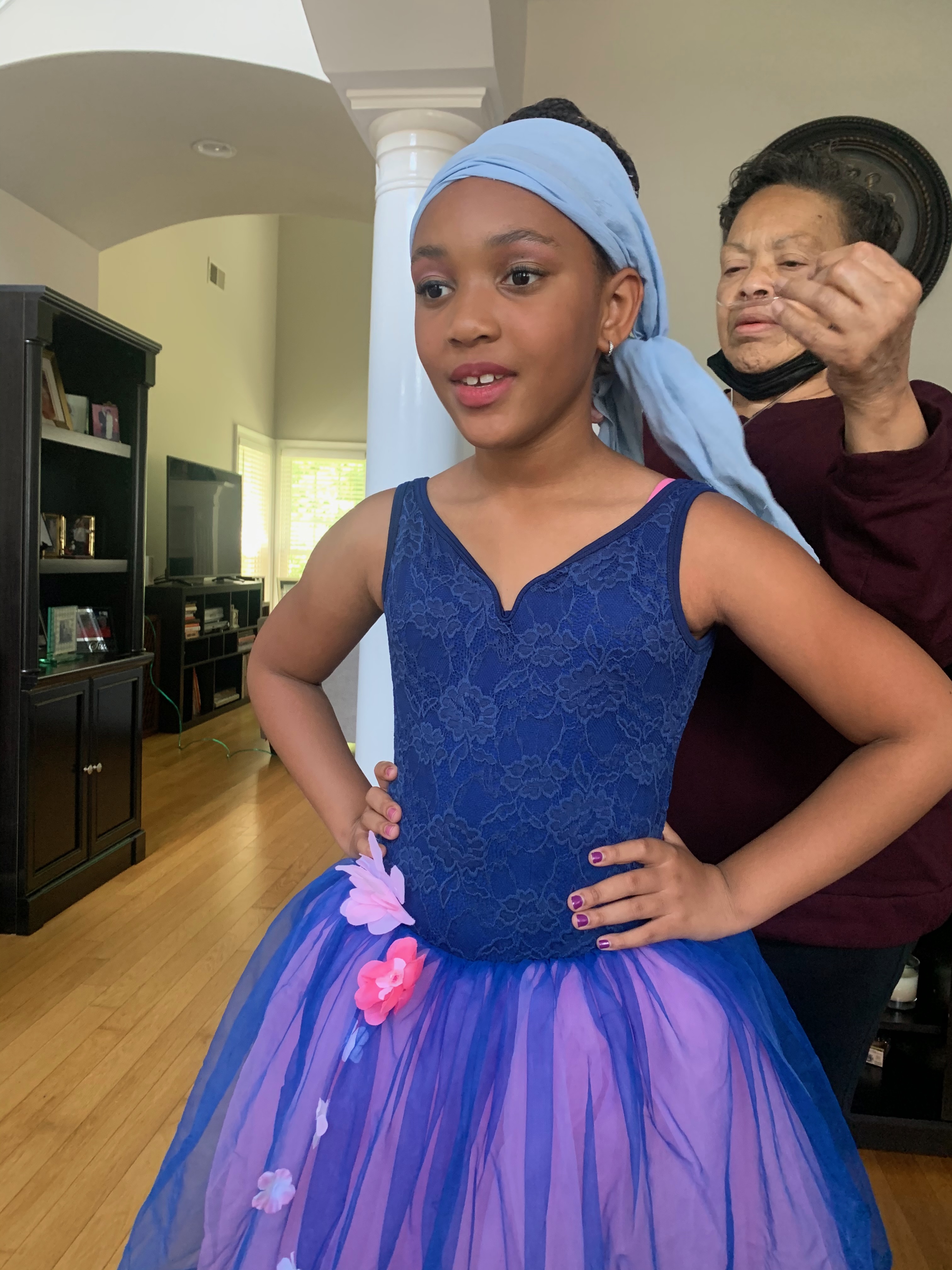 Karen helping her granddaughter get ready in a blue and purple dance dress