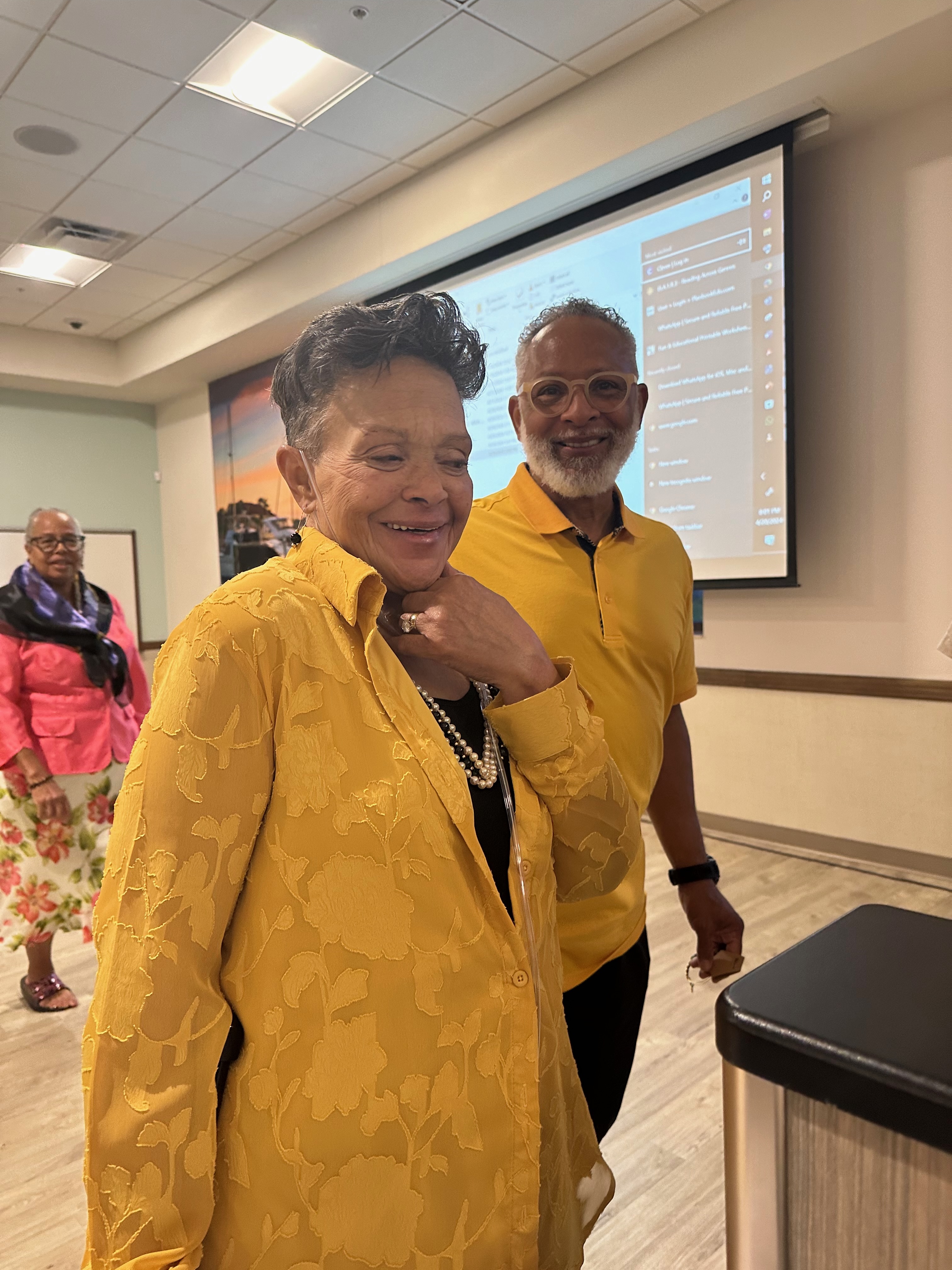 Karen smiling brightly in a golden yellow blouse