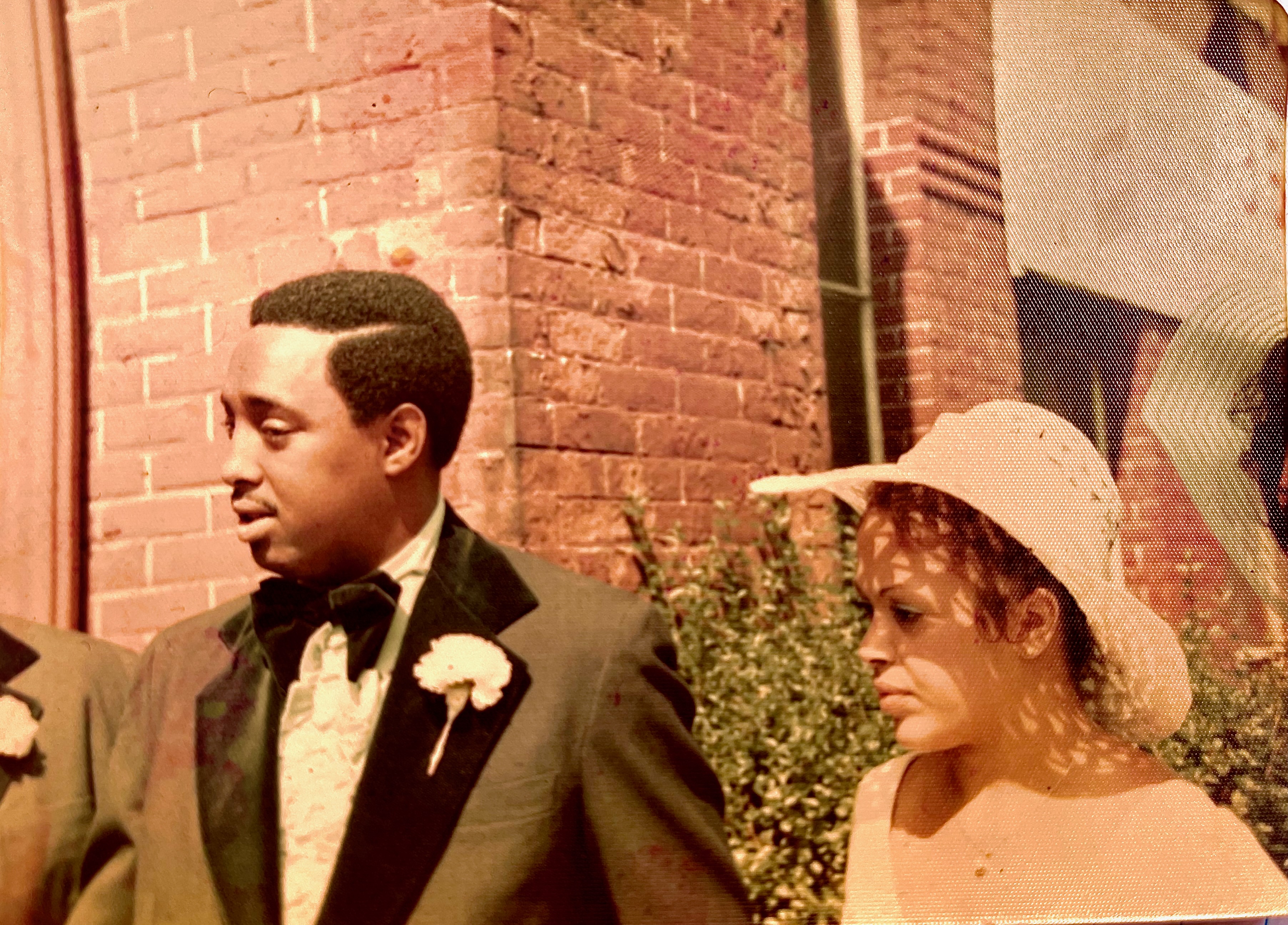 A vintage photo of Karen in a sun hat alongside a man in a tuxedo with a carnation